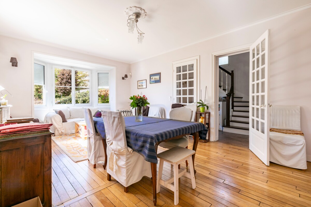 Intérieur d’une maison meulière Intérieur d'une maison meulière à Fontenay-aux-Roses, avec un salon lumineux et une table à manger.