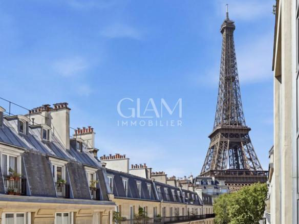 Vue sur la Tour Eiffel depuis un duplex à Paris, avec des toits parisiens au premier plan.