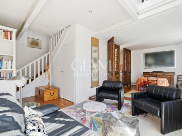 Intérieur d'un duplex à Paris avec salon et coin repas, fenêtres donnant sur la Tour Eiffel.
