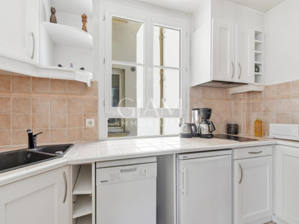 Cuisine d'un duplex à Paris avec fenêtres et équipements modernes.