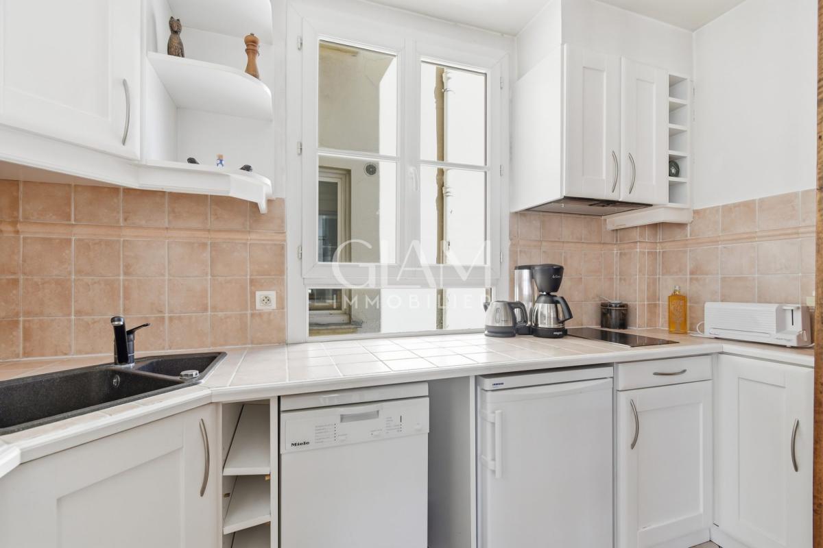 Cuisine d'un duplex à Paris avec fenêtres et équipements modernes.