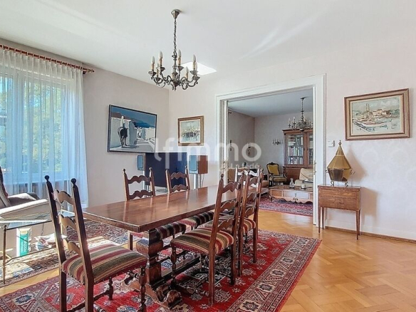 Salle à manger d'une maison bourgeoise à Barr, avec table en bois et chaises, éclairage naturel.