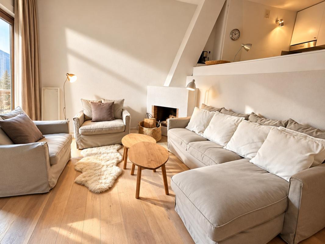 Salon d’un appartement lumineux à Morzine Salon lumineux d'un appartement avec canapé et fauteuils, parquet clair et vue sur les montagnes.
