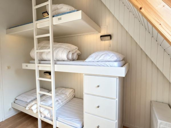 Chambre d'un appartement lumineux avec lits superposés et rangement à Morzine.