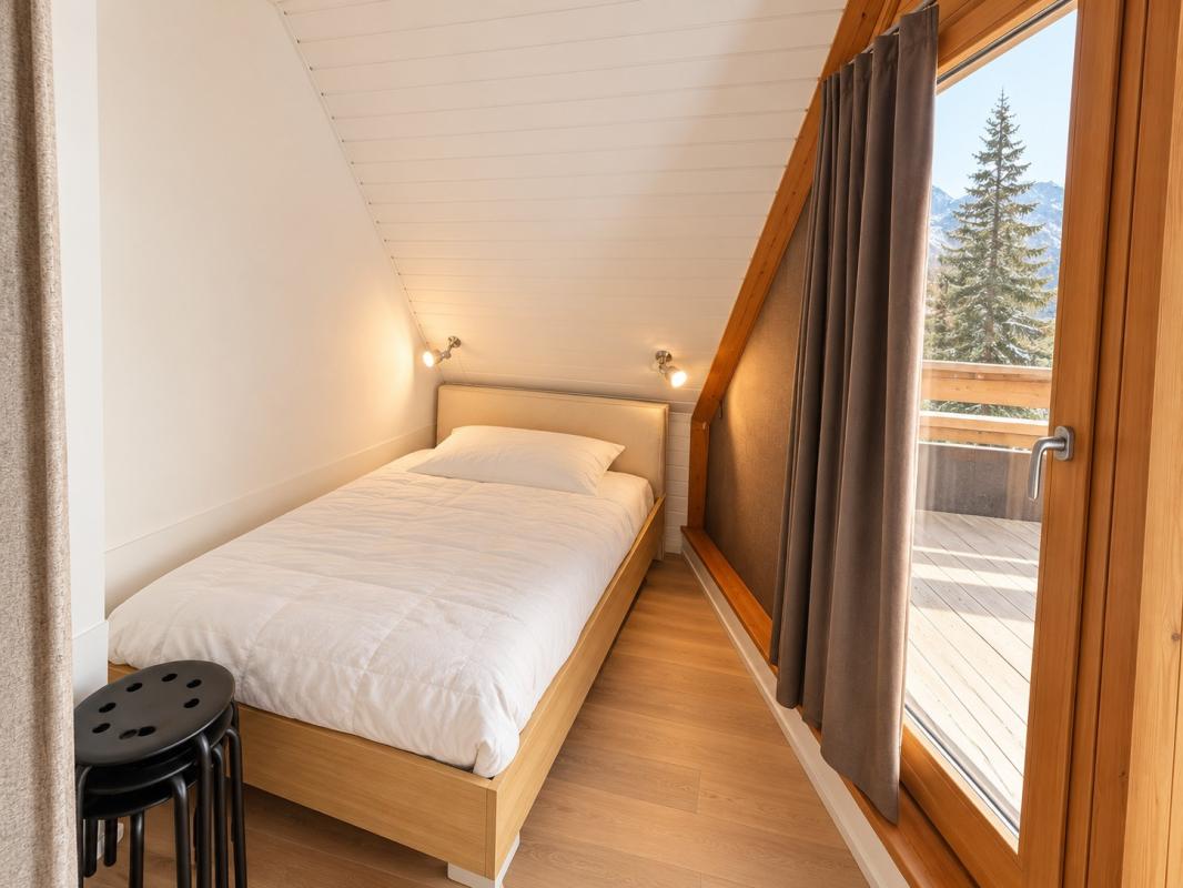 Chambre d’appartement à Morzine Chambre d'un appartement lumineux avec lit simple et vue sur les montagnes à Morzine.