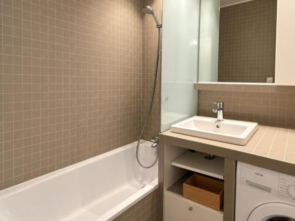 Salle de bain d'un appartement lumineux avec baignoire et lavabo à Morzine.