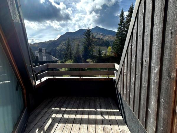 Balcon d'un appartement avec vue sur les montagnes à Morzine, lumineux et en bois.