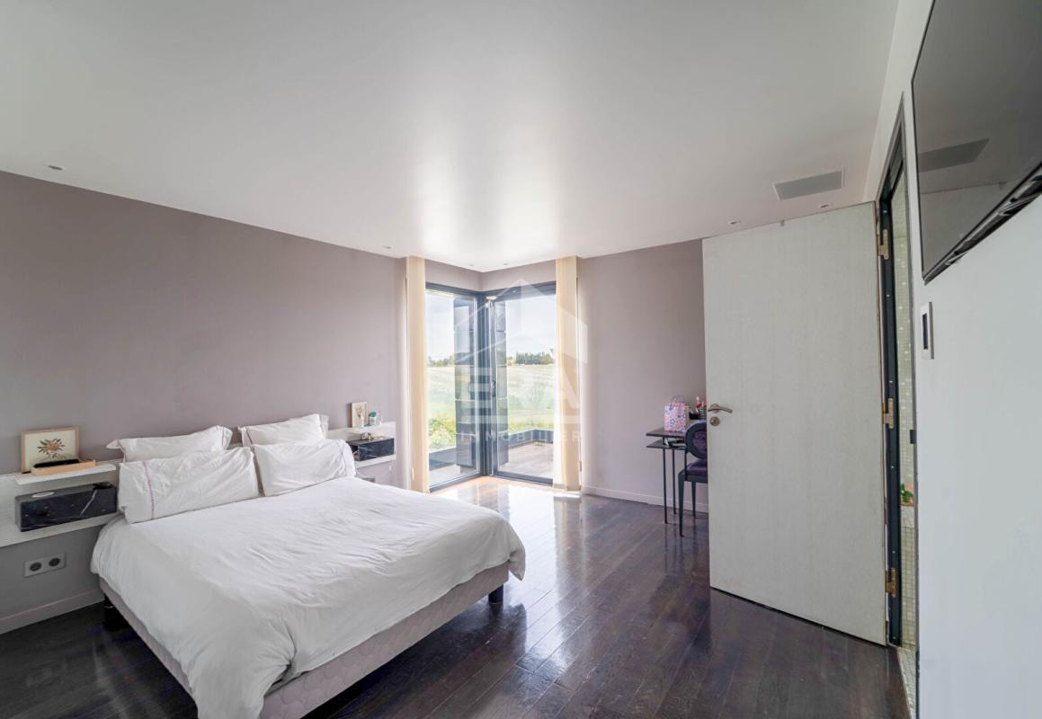 Chambre d'une maison d'architecte moderne avec vue sur l'extérieur.