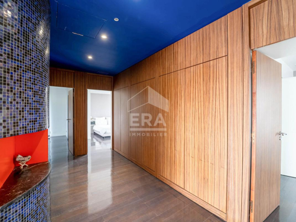 Intérieur d'une maison d'architecte avec murs en bois et un sol en parquet, éclairage moderne.