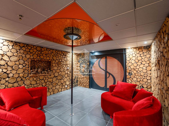 Intérieur d'une maison d'architecte avec murs en rondins et canapés rouges.
