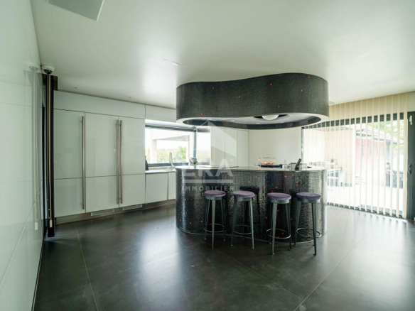 Intérieur d'une maison d'architecte moderne avec bar et cuisine ouverte.