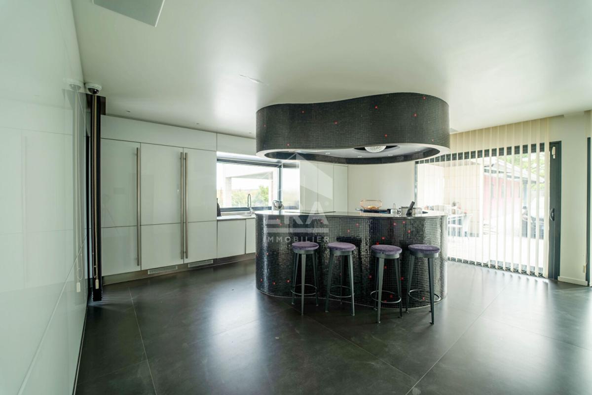 Intérieur d'une maison d'architecte moderne avec bar et cuisine ouverte.