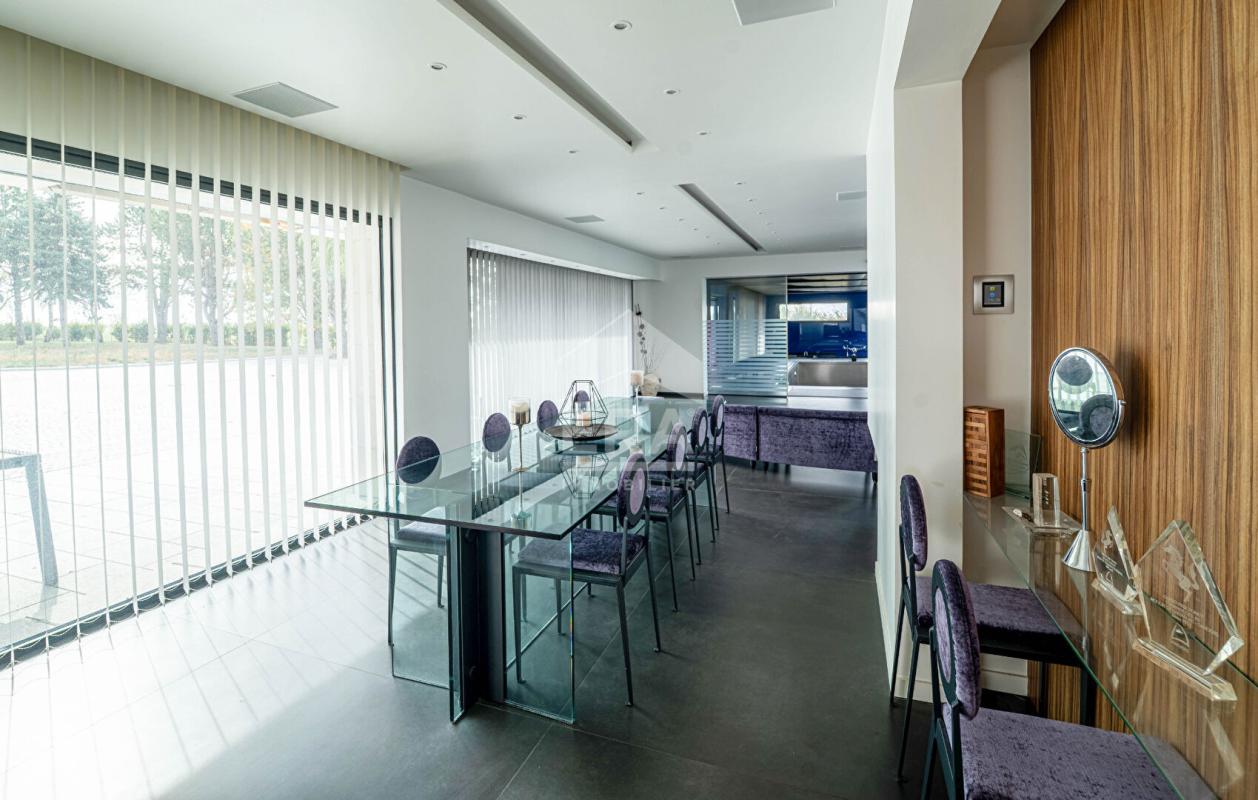 Intérieur d'une maison d'architecte moderne avec salle à manger et cuisine ouverte.
