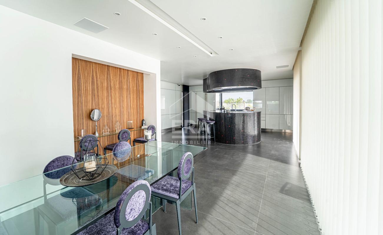 Intérieur d'une maison d'architecte moderne avec salle à manger et cuisine ouverte.
