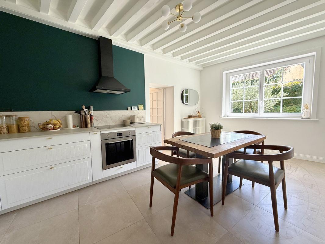Cuisine d’une demeure historique à Chaponost Cuisine moderne et élégante d'une demeure historique à Chaponost avec table en bois et chaises.