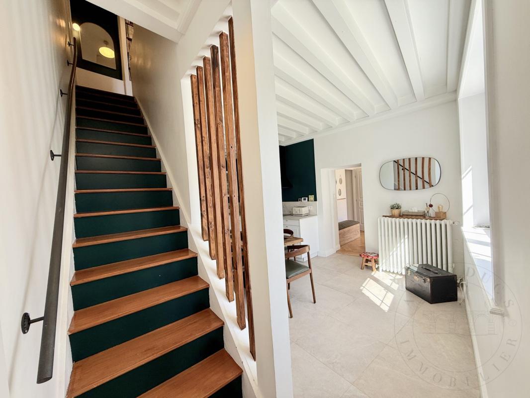 Intérieur d’une demeure historique à Chaponost Intérieur d'une demeure historique avec un escalier en bois et un espace lumineux.
