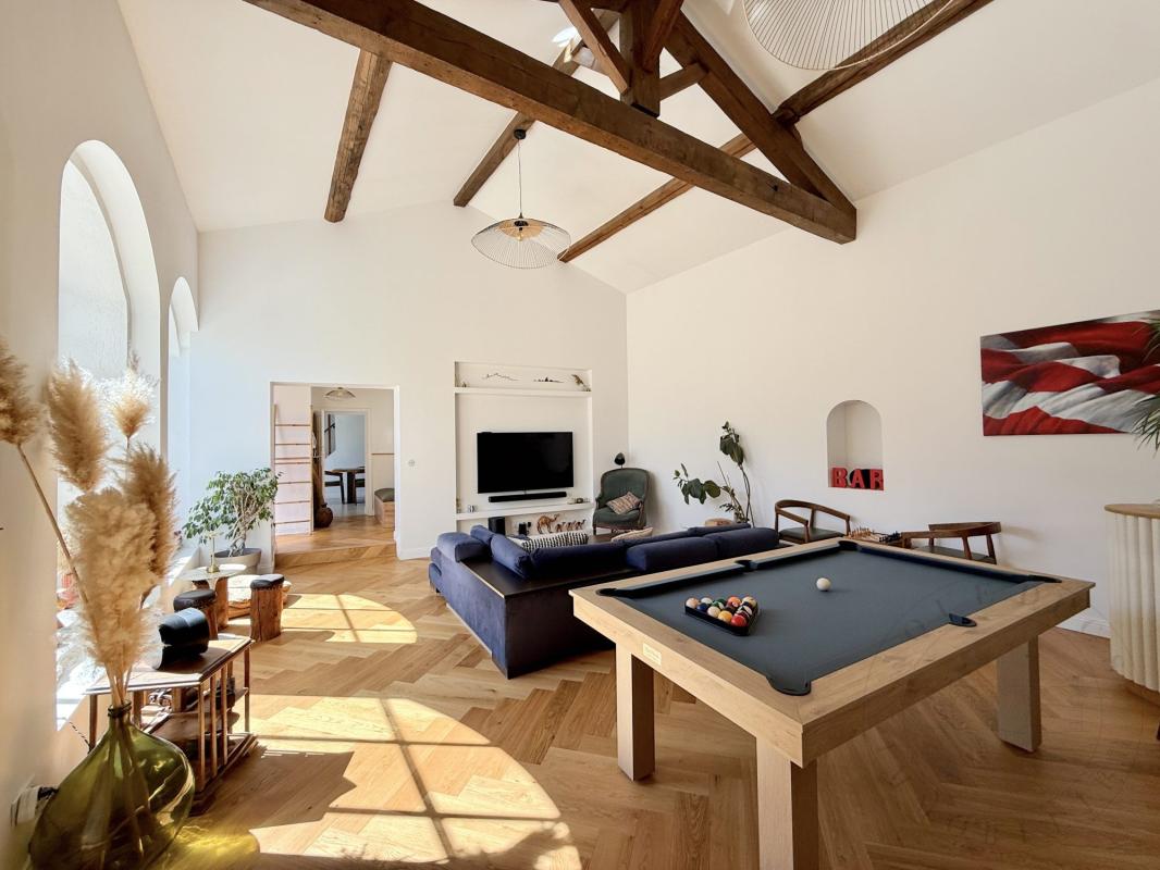 Intérieur d’une demeure historique à Chaponost Intérieur d'une demeure historique rénovée avec un salon lumineux et une table de billard.