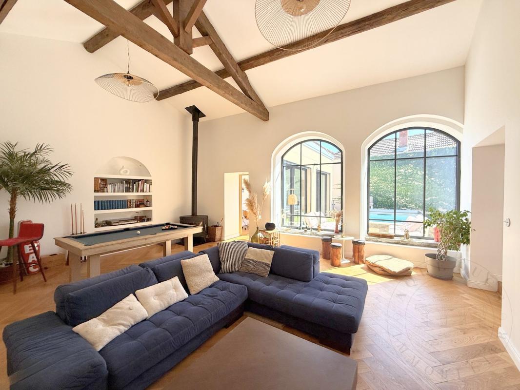 Intérieur d’une demeure historique à Chaponost Intérieur d'une demeure historique rénovée avec un salon lumineux et des fenêtres arrondies.
