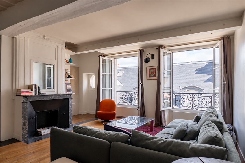 Salon d’appartement dans le Marais Salon lumineux d'un appartement meublé au 3ème étage dans le Marais, Paris, avec fenêtres ouvertes.