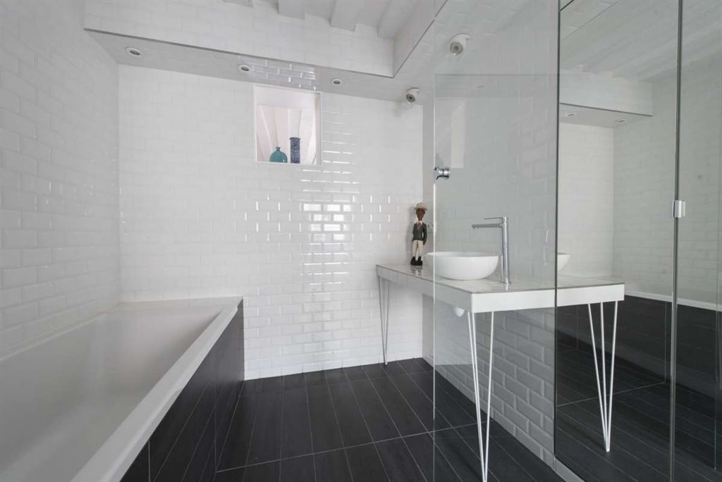 Salle de bain moderne Salle de bain moderne avec baignoire et lavabo sur un meuble design, carrelage blanc et noir.