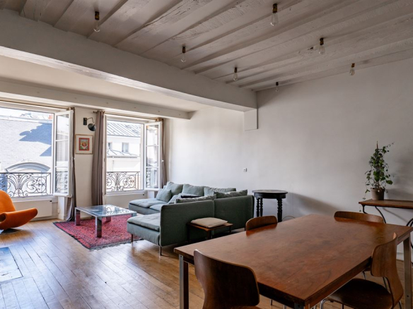 Intérieur d'un appartement dans le Marais à Paris, avec salon lumineux et cuisine ouverte.