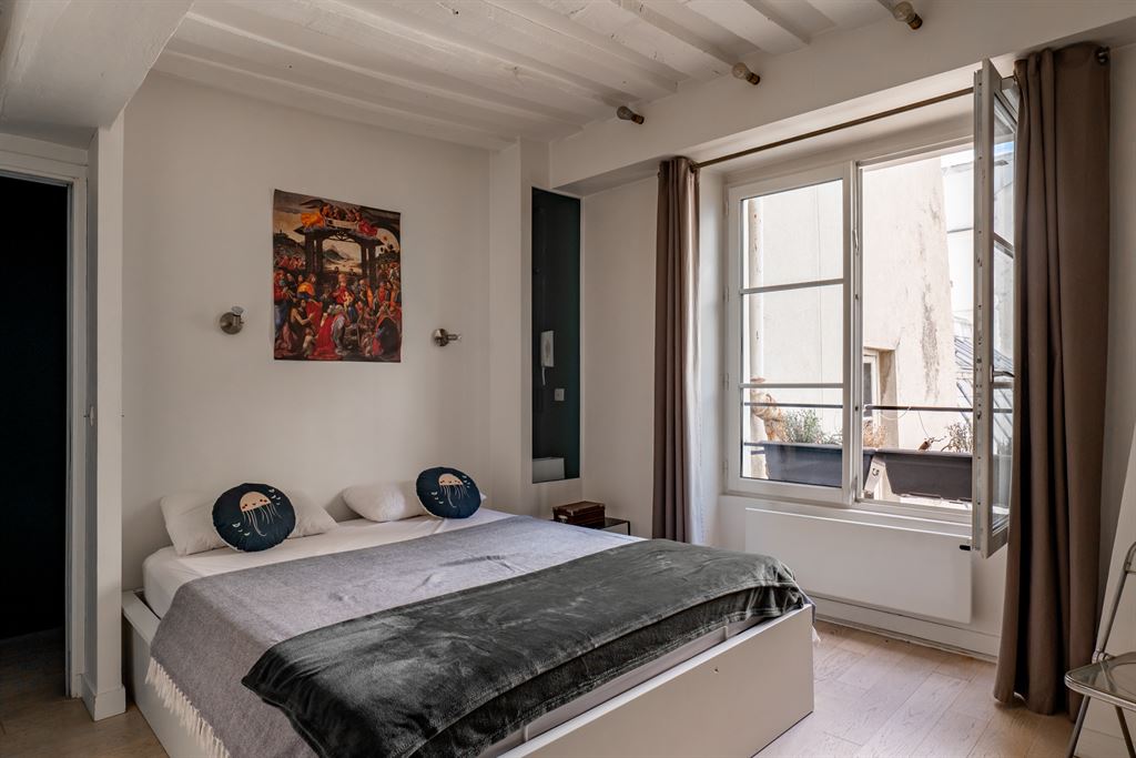 Chambre d’appartement au Marais Chambre d'un appartement meublé au Marais, Paris, avec lit double et fenêtres ouvertes.