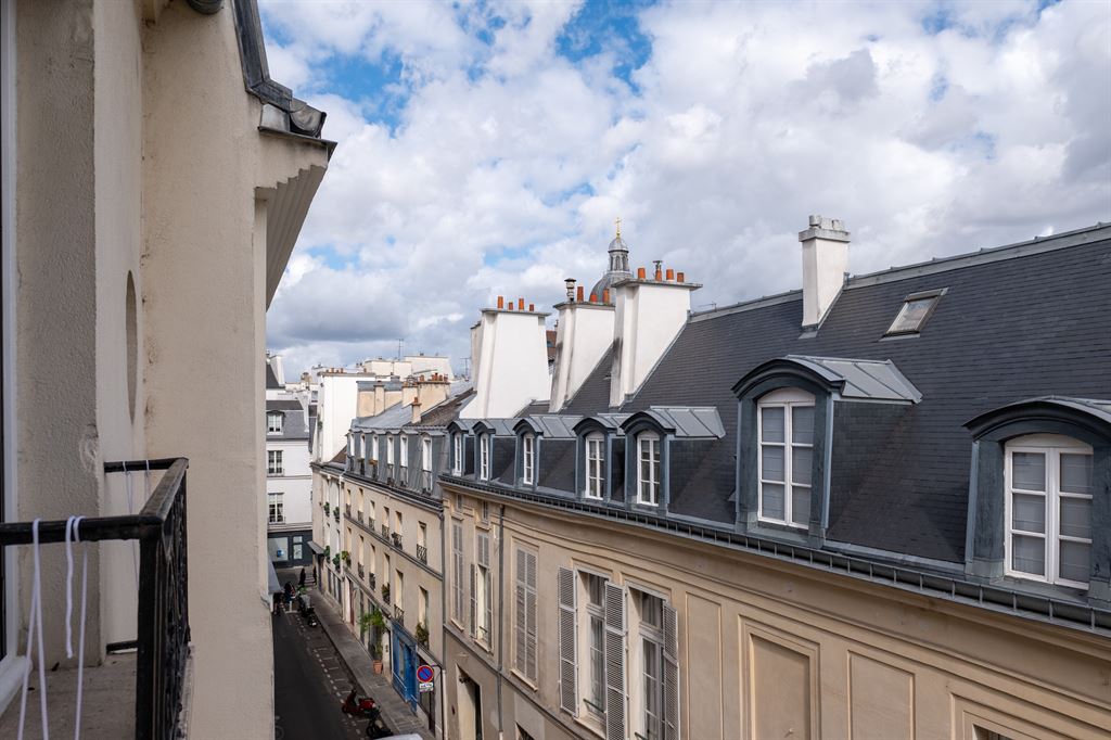 Vue des toits du Marais à Paris Vue des toits du Marais à Paris avec des bâtiments historiques et un ciel nuageux.