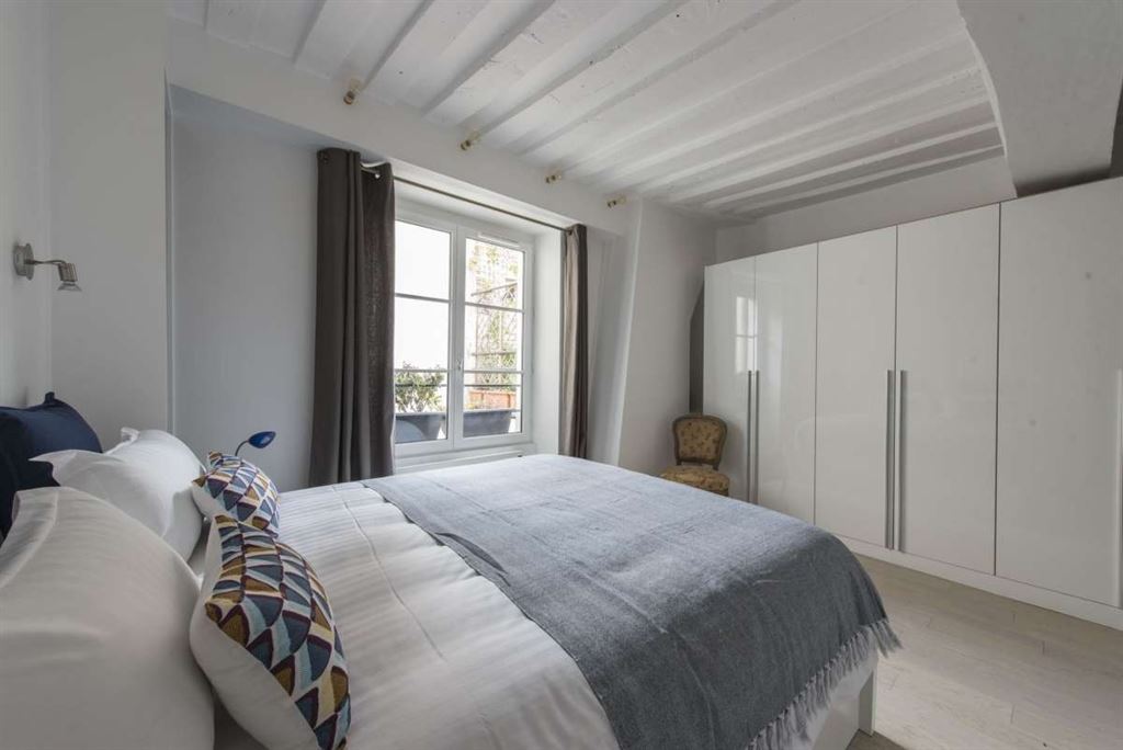 Chambre d’appartement dans le Marais Chambre d'un appartement meublé au 3ème étage dans le Marais, Paris, avec fenêtres et lit double.