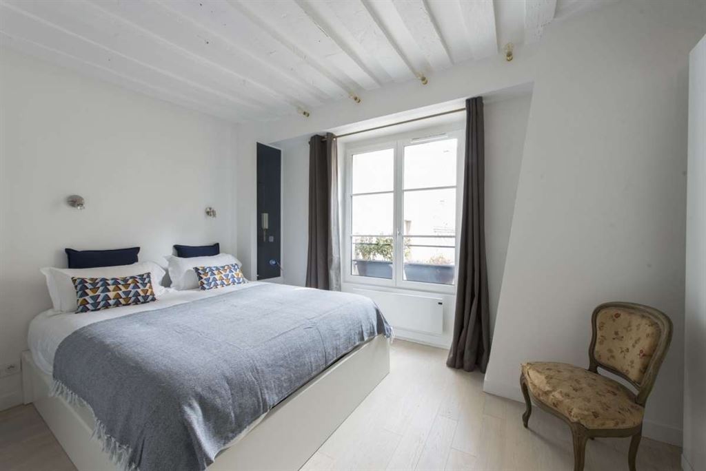 Chambre d’appartement au Marais Chambre d'un appartement meublé au Marais, Paris, avec lit double et fenêtre.