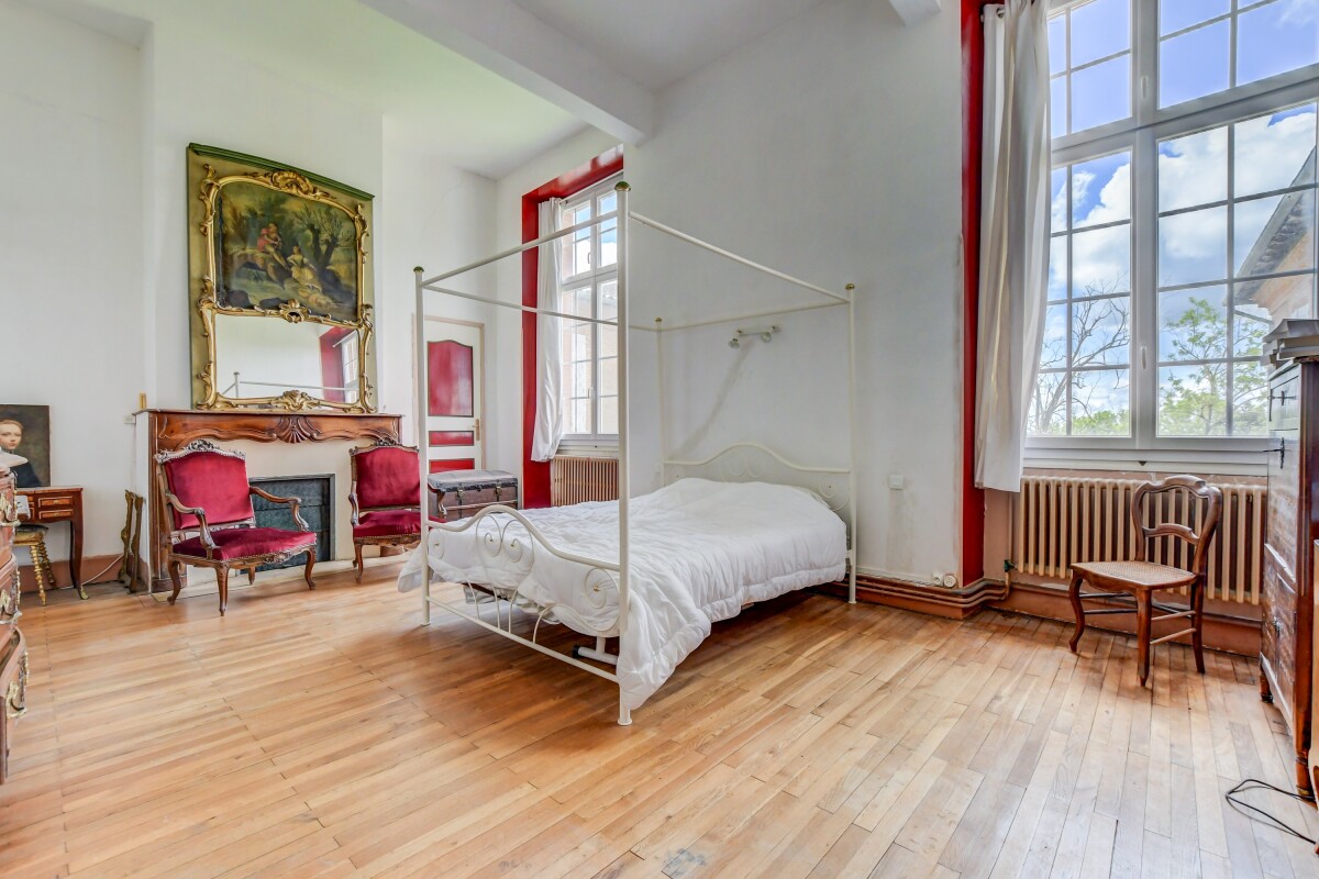 Chambre d’un château à Lanta Chambre d'un château du XVIIe siècle à Lanta, avec un lit à baldaquin et des meubles anciens.