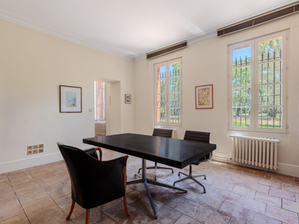 Intérieur d'une maison du XIXe siècle avec un bureau et des fenêtres donnant sur le parc.