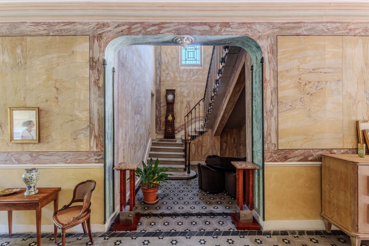 Intérieur d’une maison de maître Intérieur d'une maison de maître du XIXe siècle avec un couloir traversant et un escalier en pierre.