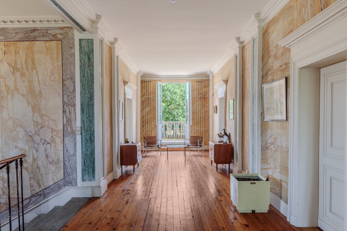 Intérieur d’une maison de maître Intérieur d'une maison du XIXe siècle avec un couloir lumineux et des murs ornés de marbre.