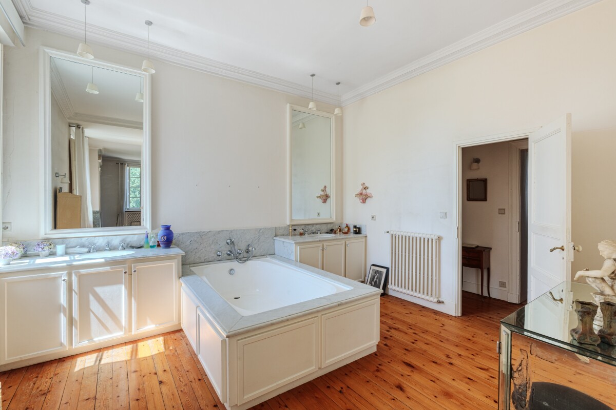 Salle de bain élégante Salle de bain spacieuse avec baignoire, miroir et lumière naturelle