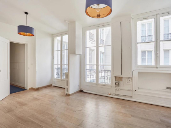 Intérieur d'un appartement à rénover avec parquet et fenêtres sur cour à Paris 8ème.