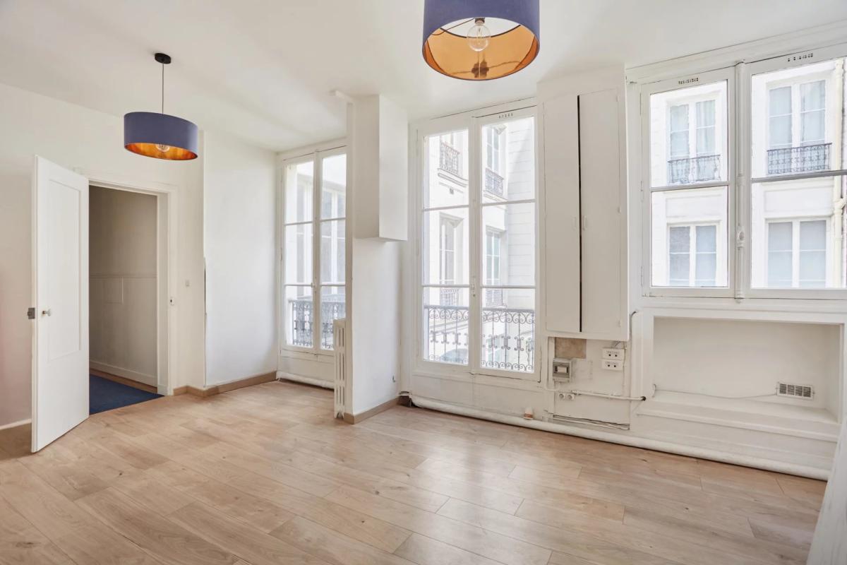 Appartement à rénover à Paris 8ème Intérieur d'un appartement à rénover avec parquet et fenêtres sur cour à Paris 8ème.