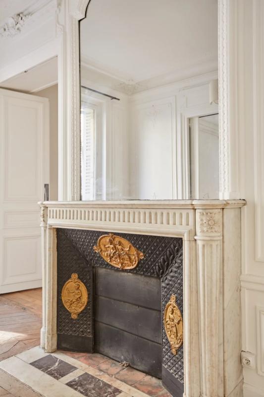 Cheminée dans un appartement parisien Cheminée en marbre avec décorations dorées dans un appartement à Paris.