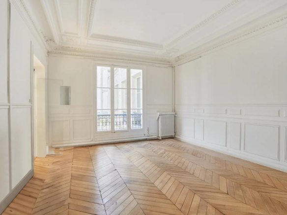 Intérieur d'un appartement à rénover avec parquet en point de Hongrie et moulures, Paris 8ème.