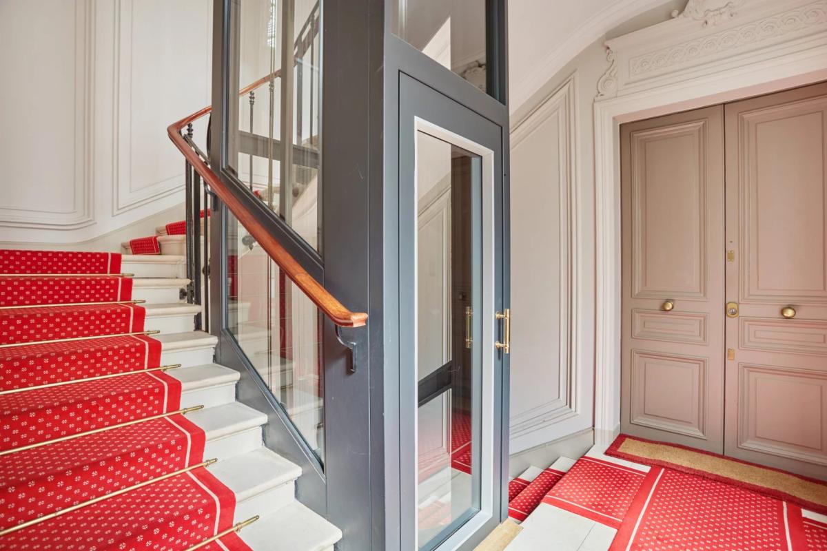 Ascenseur vitré dans un immeuble bourgeois Cage d'escalier avec ascenseur vitré dans un immeuble bourgeois à Paris 8ème.