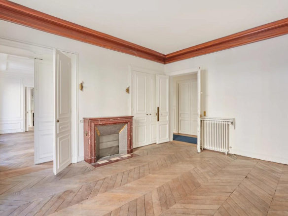 Intérieur d'un appartement à rénover avec parquet et cheminée, Paris 8ème.