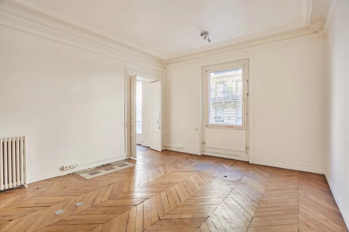 Appartement à rénover à Paris 8ème Intérieur d'un appartement à rénover avec parquet en points de Hongrie et murs blancs, Paris 8ème.
