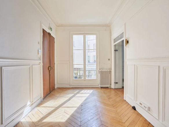 Intérieur d'un appartement à rénover avec parquet en point de Hongrie et moulures, Paris 8ème.