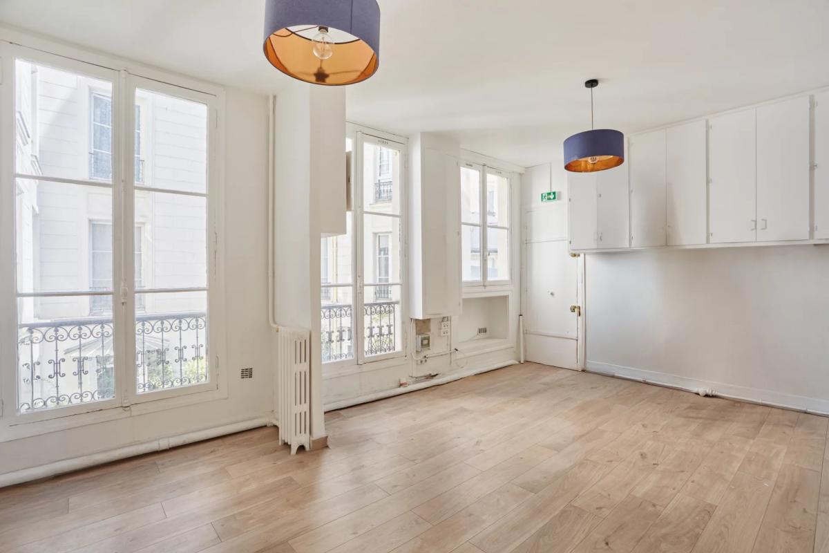 Appartement à rénover à Paris 8ème Intérieur d'un appartement à rénover de 200 m² à Paris, avec parquet et fenêtres donnant sur la rue.