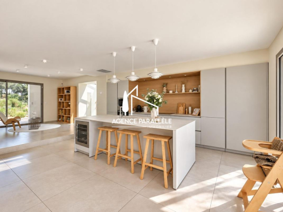 Intérieur d'une villa contemporaine à Nîmes avec cuisine ouverte et espace lumineux.