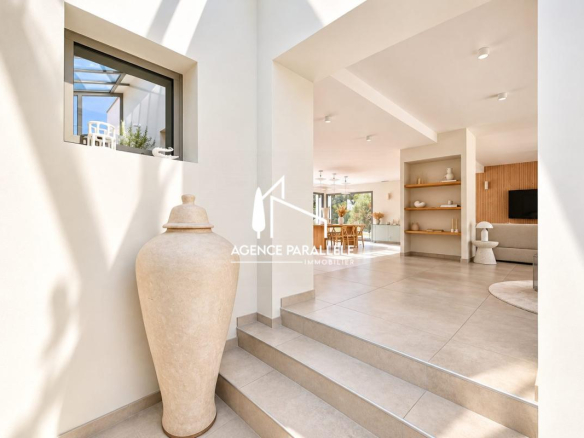 Intérieur d'une villa contemporaine à Nîmes avec un grand vase et un espace lumineux.