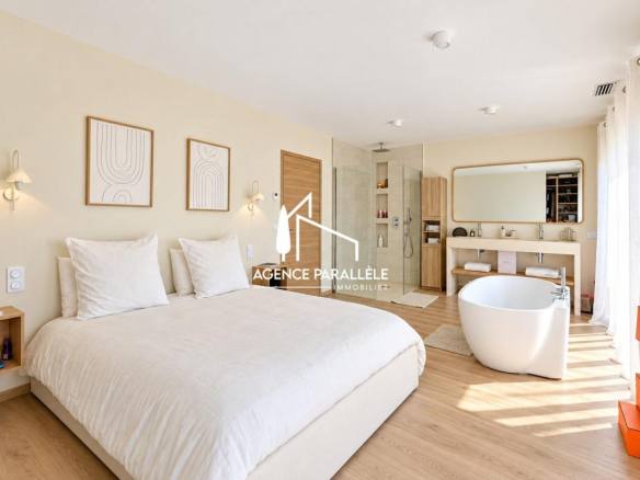 Chambre moderne avec baignoire et salle de bain attenante dans une villa contemporaine à Nîmes.