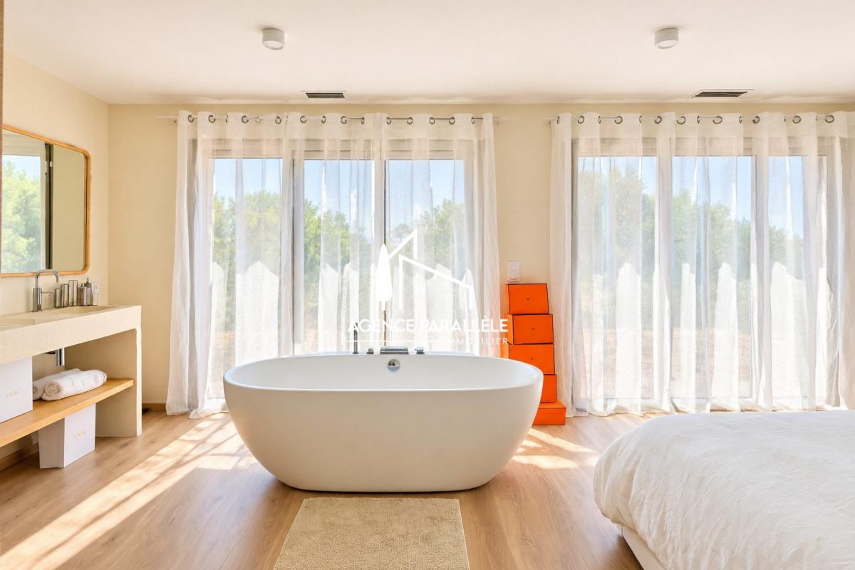 Chambre d’une villa contemporaine à Nîmes Chambre lumineuse avec baignoire et grandes fenêtres dans une villa contemporaine à Nîmes.