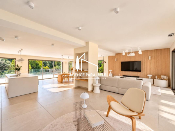 Intérieur d'une villa contemporaine à Nîmes avec salon lumineux et cuisine ouverte.
