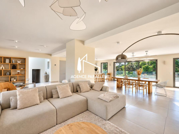 Intérieur d'une villa contemporaine à Nîmes avec salon spacieux et grandes baies vitrées.