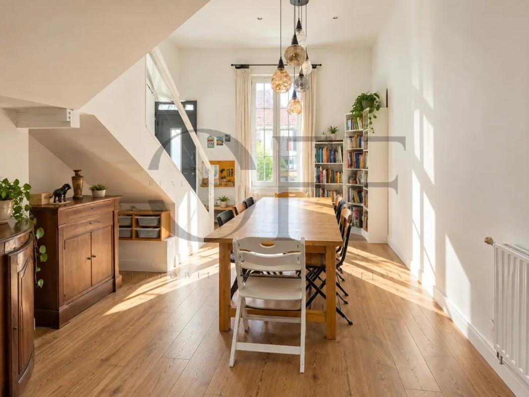 Intérieur d’une maison de ville à Marseille Intérieur d'une maison de ville rénovée avec une grande table à manger et des étagères, lumière naturelle abondante.